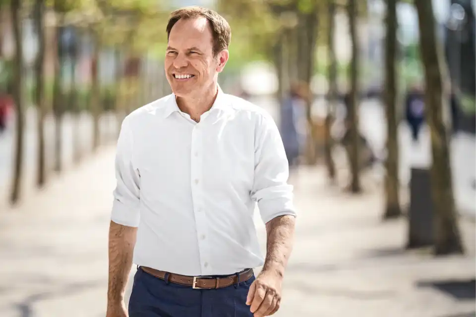Stephan Keller schreitet durch eine Allee