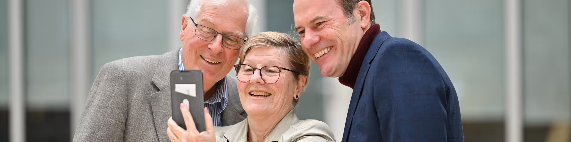 Dr. Stephan Keller posiert mit zwei Personen für ein Selfie